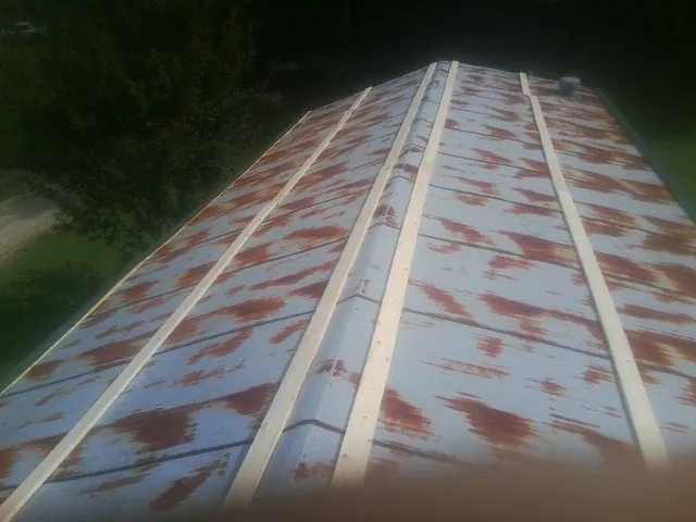 Rusted metal roof panels with new wood purlins before replacement — Storm Damage Roof Repair in Bryans Road by Roofing Brothers