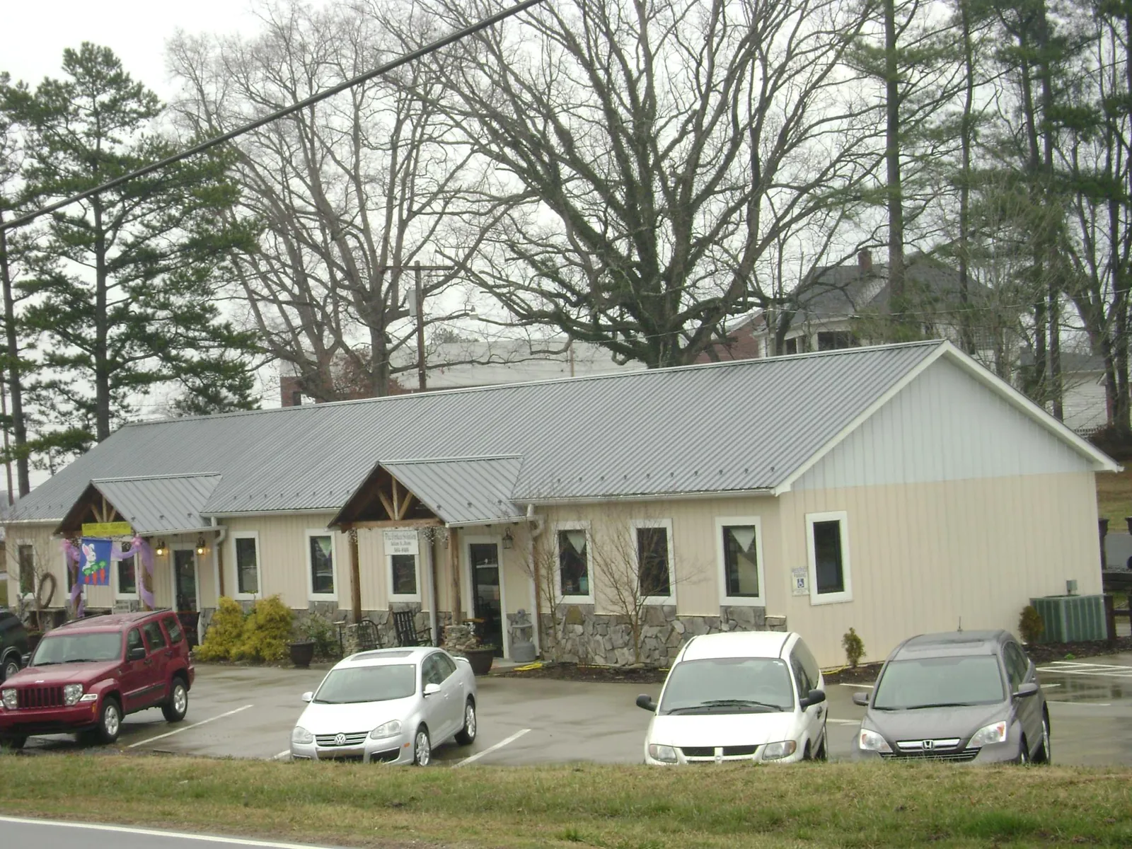 Gray metal roof with timber entry brackets on a small commercial building in Bryans Road