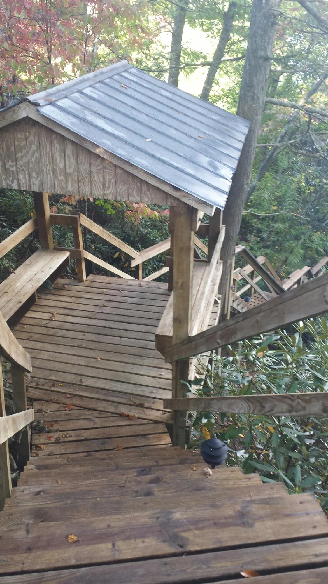Metal roofed shelter over wooden steps on a wooded walkway — Skylight Repair & Installation work by our crew in Bryans Road