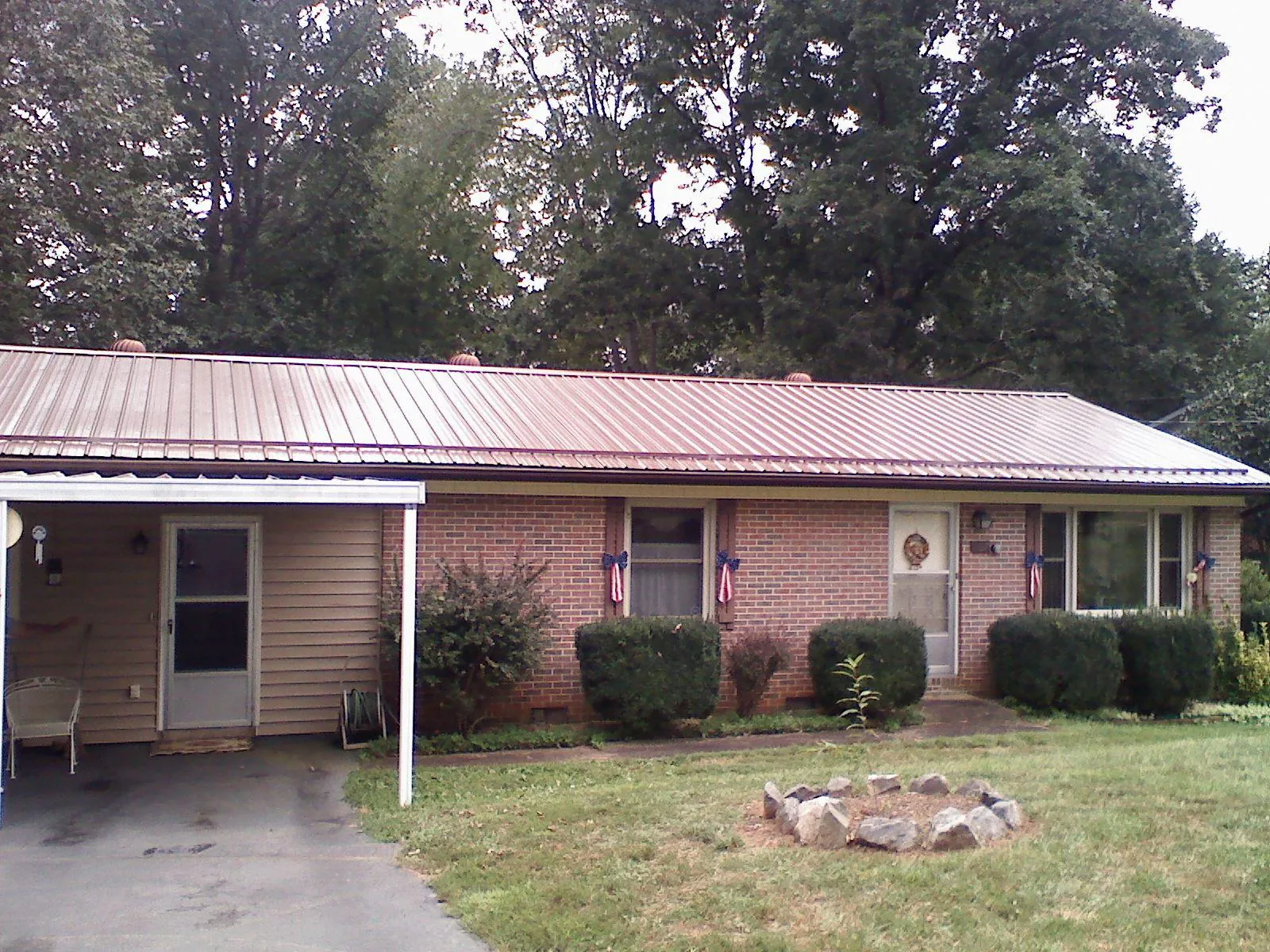 Bronze metal roof and carport on a brick ranch home — Roof Repair work by our crew in Bryans Road